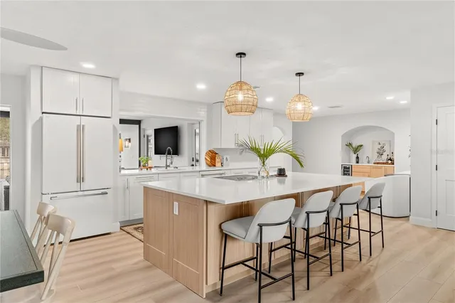 a kitchen with stainless steel appliances kitchen island granite countertop a table chairs sink and cabinets