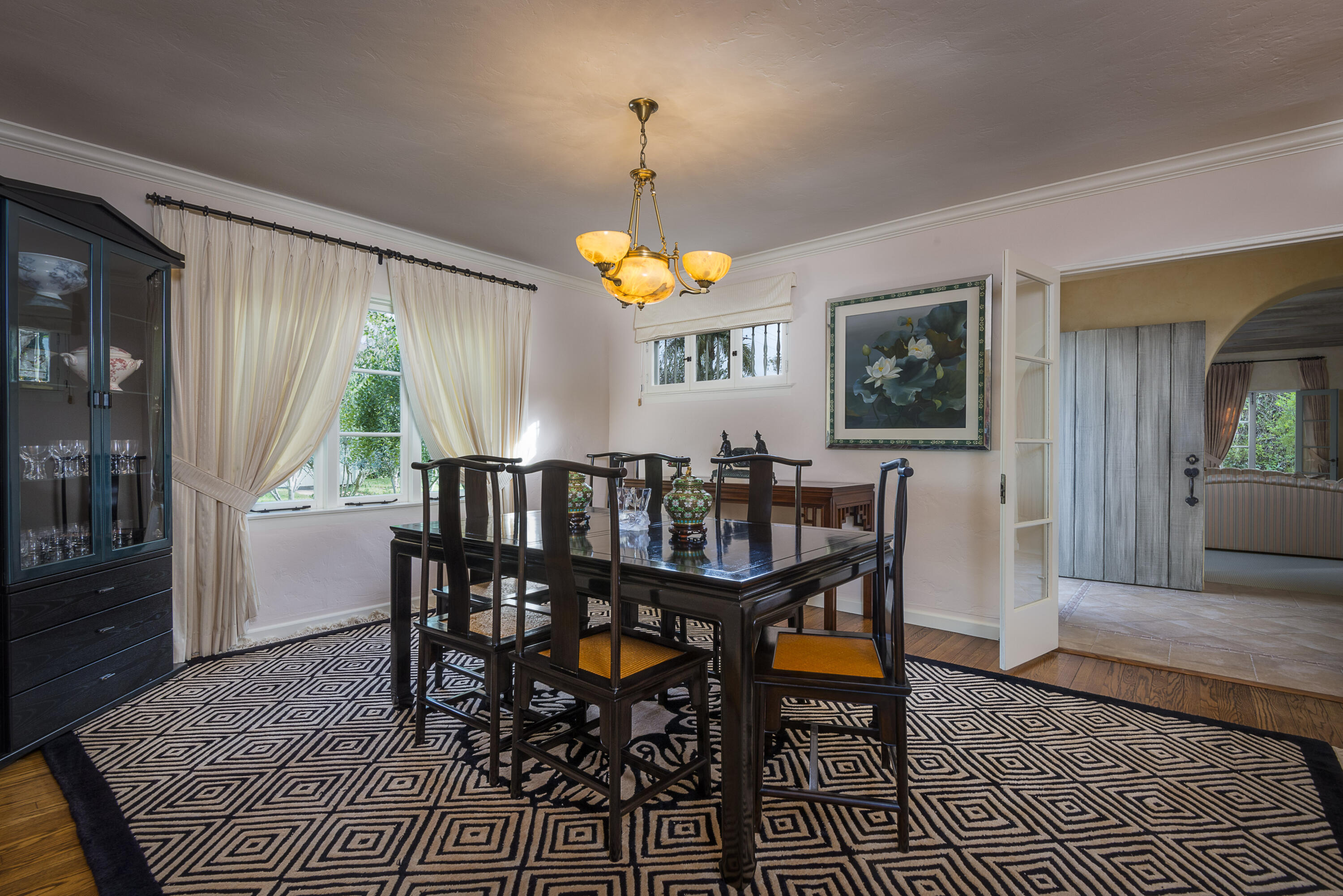 2311 Santa Barbara Street Santa Barbara, CA 93105 - Photo 7 of 20 a dining room with wooden floor a chandelier a wooden table and chairs