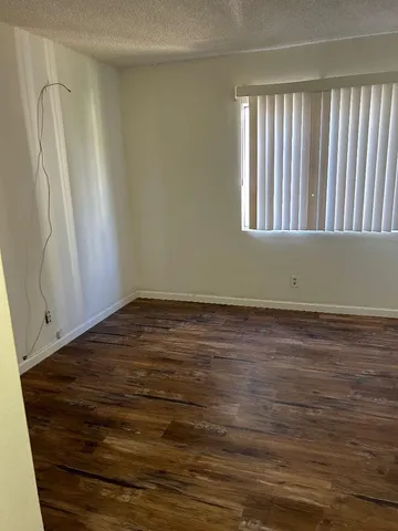 a view of a room with wooden floor and a window