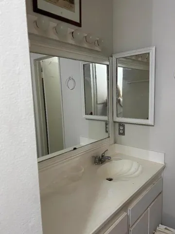 a bathroom with a granite countertop sink and a mirror