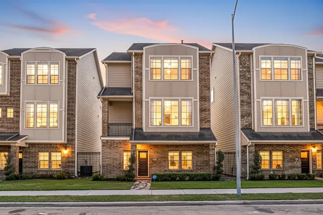 a front view of a residential apartment building with a yard