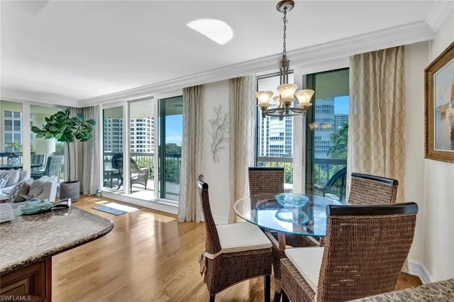 a dining room with furniture wooden floor and a chandelier
