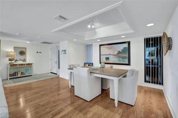 a living room with stainless steel appliances kitchen island hardwood floor and a large window