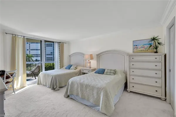 a bedroom with two beds and a large window