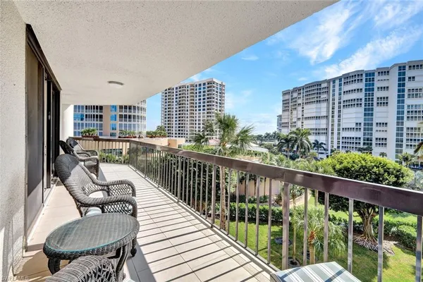 a balcony with chairs and city view