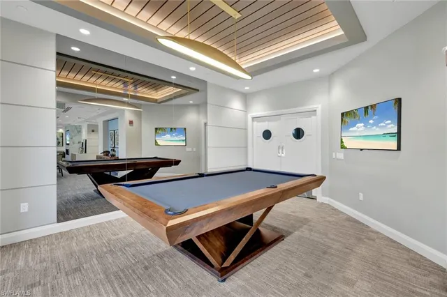 a room with pool table and windows