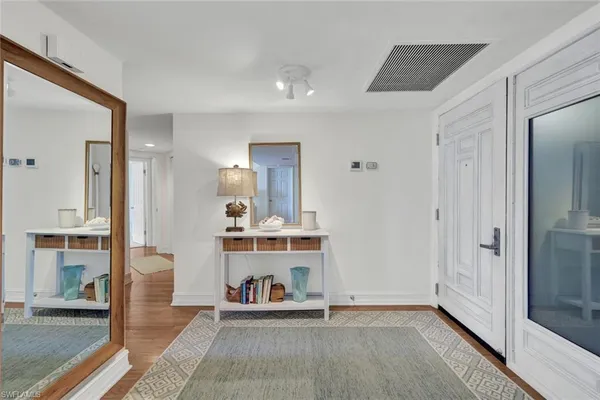a view of a hallway with wooden floor and furniture