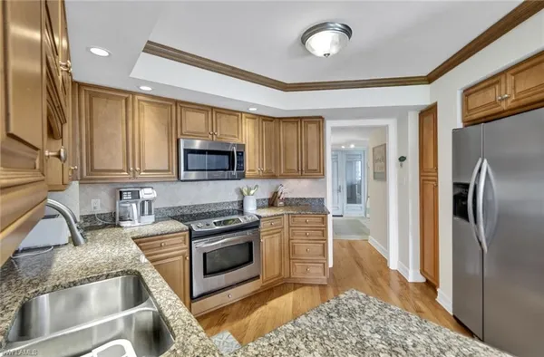 a kitchen with stainless steel appliances granite countertop a refrigerator stove and sink