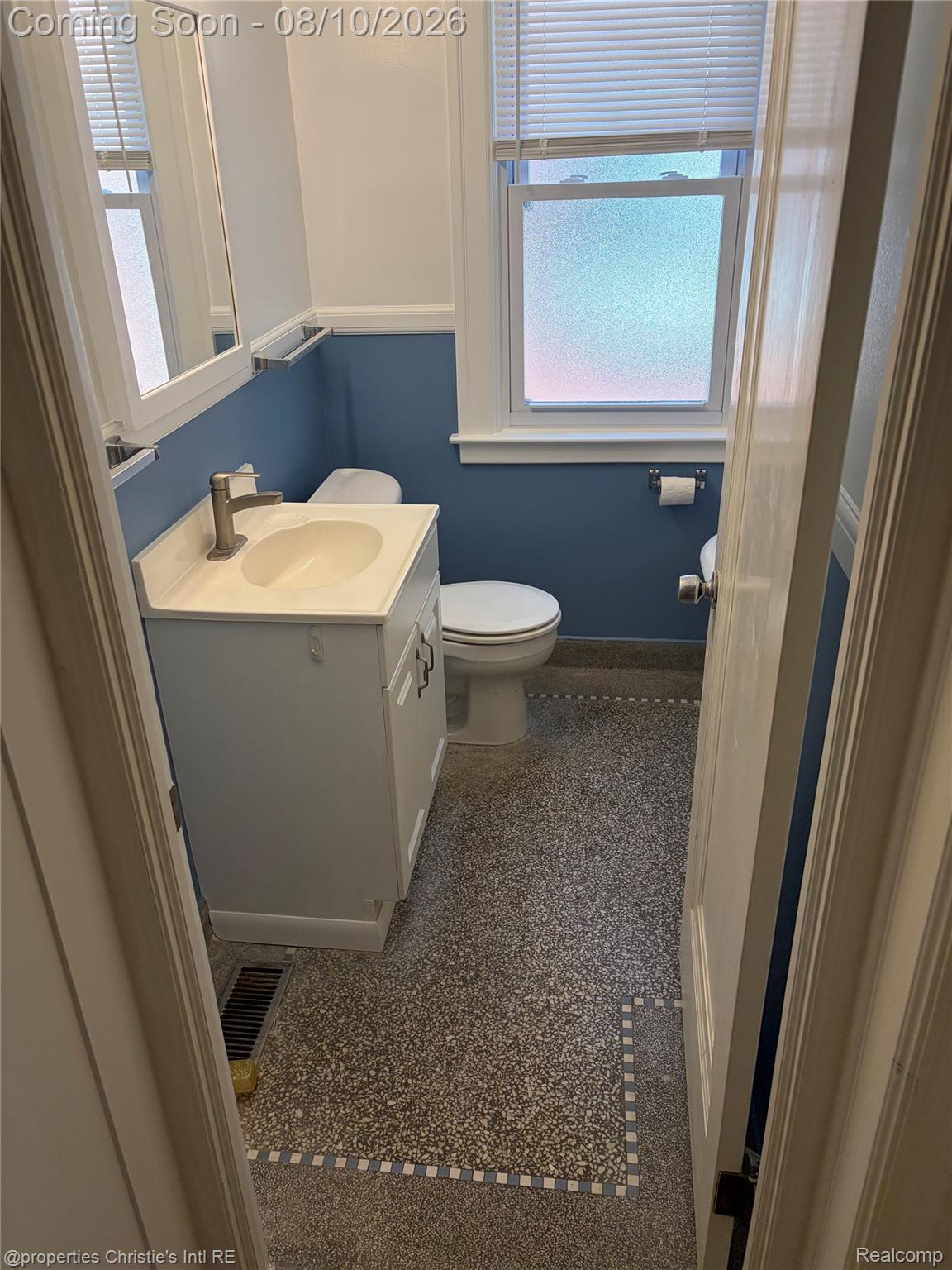 858 Nottingham Road Grosse Pointe, MI 48230 - Photo 5 of 16 Primary Bathroom featuring a white vanity with an integrated sink, a contemporary brushed nickel faucet, a medicine cabinet with a mirrored door, a window with privacy film and blinds, and patterned terrazzo-style flooring