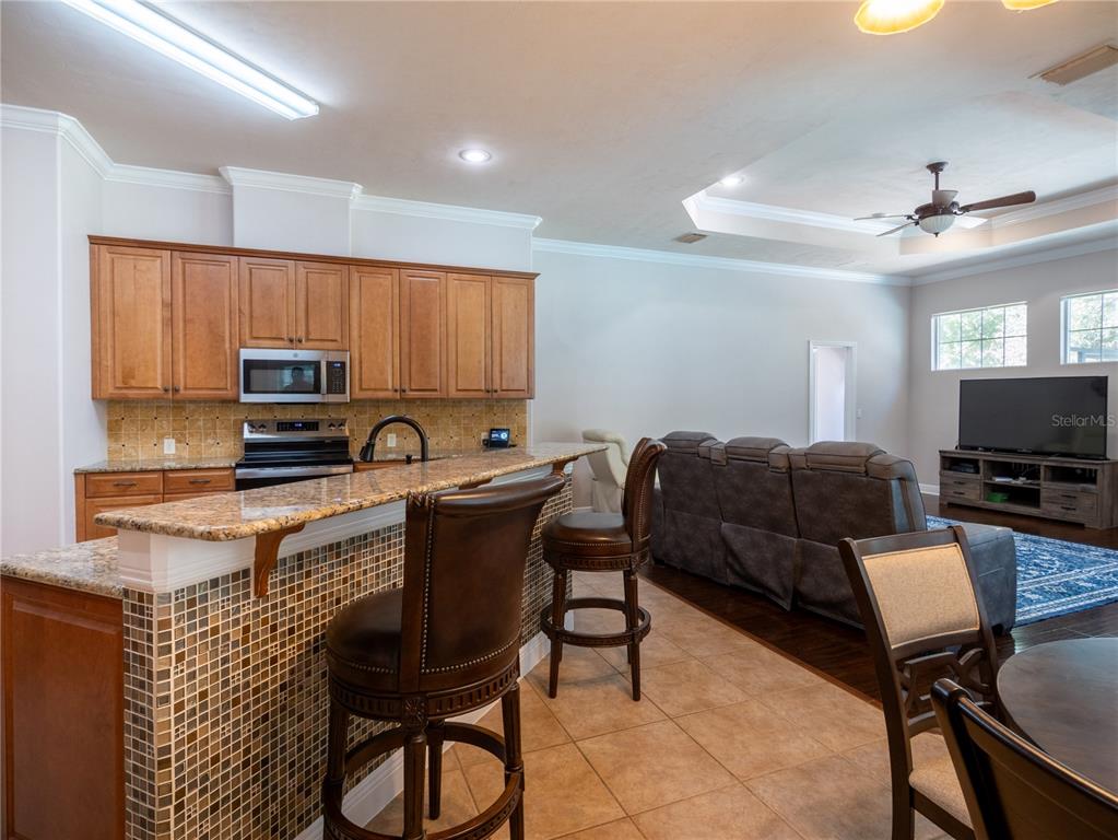 1488 Southwest 84th Terrace Gainesville, FL 32607 - Photo 12 of 31 a living room with furniture a flat screen tv and kitchen view