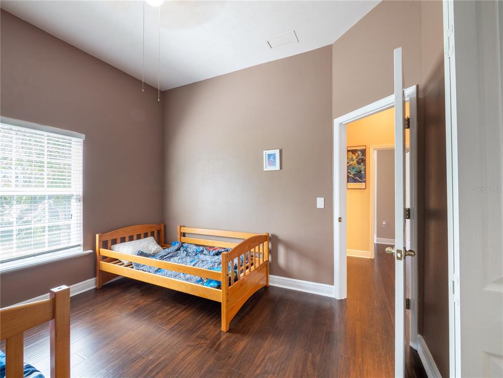1488 Southwest 84th Terrace Gainesville, FL 32607 - Photo 21 of 31 a bedroom with a bed and wooden floor