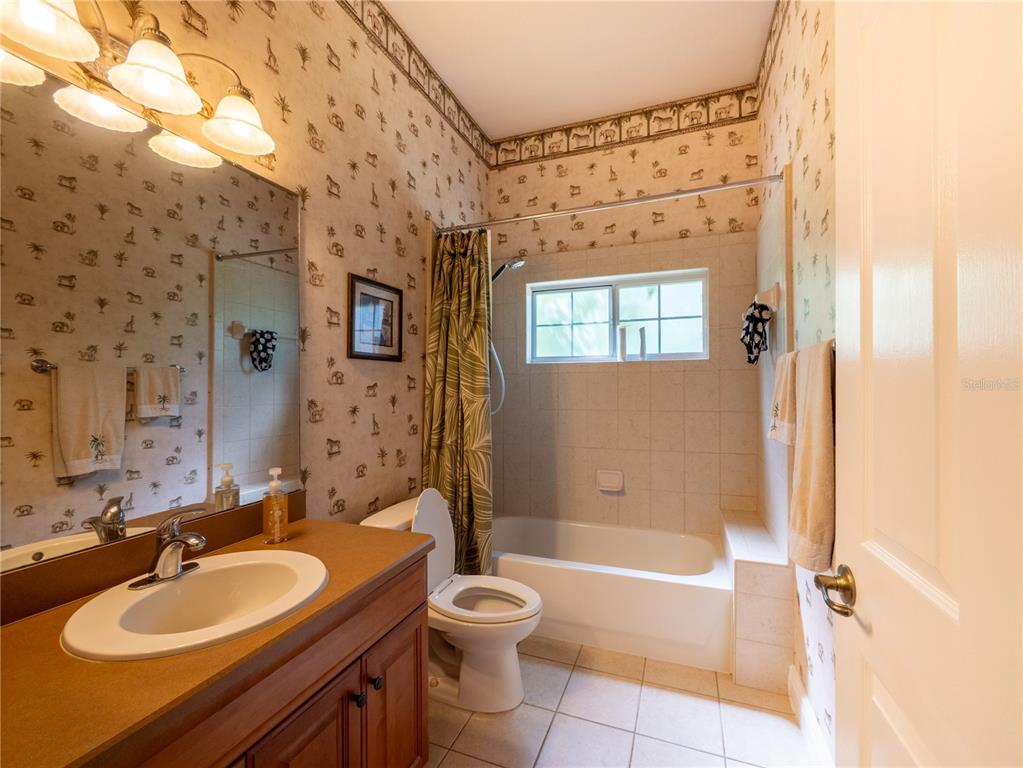 1488 Southwest 84th Terrace Gainesville, FL 32607 - Photo 24 of 31 a bathroom with a granite countertop sink toilet a mirror and shower