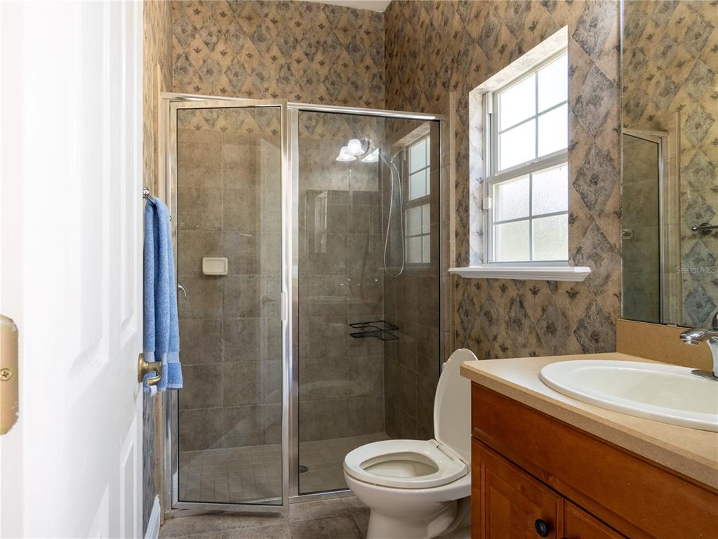 1488 Southwest 84th Terrace Gainesville, FL 32607 - Photo 25 of 31 a bathroom with a granite countertop sink toilet and shower