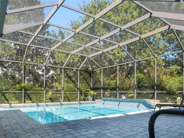 a view of a swimming pool with a yard and sitting area