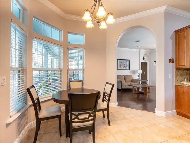 a dining room with furniture a chandelier and wooden floor