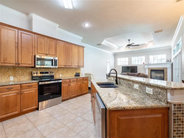a kitchen with granite countertop a stove sink and microwave