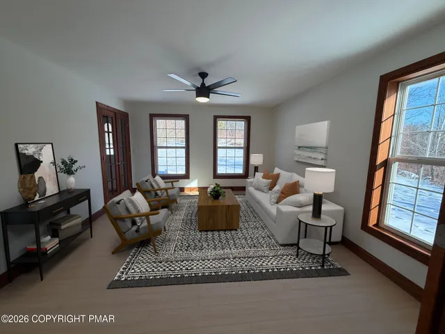 a living room with furniture a large window and a flat screen tv