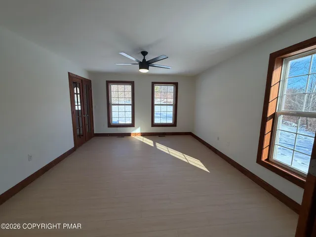 an empty room with windows and cabinet