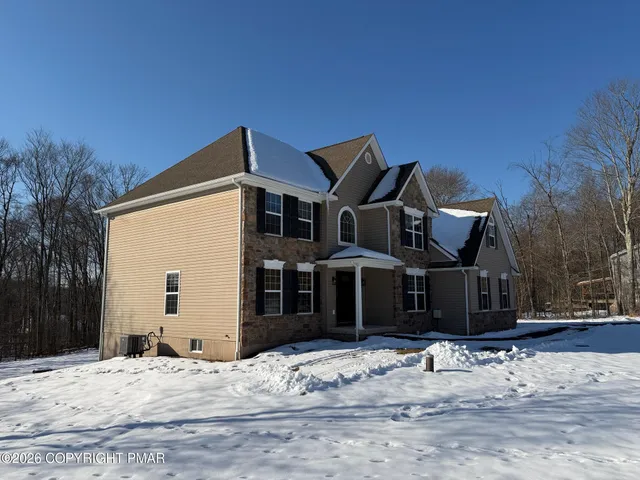 a view of a house with snow on the road