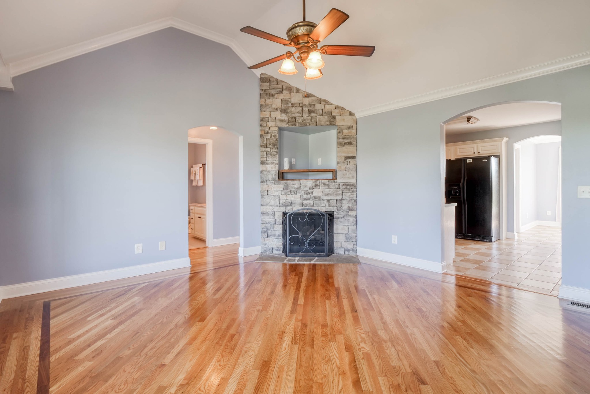724 Lear Road Portland, TN 37148 - Photo 6 of 32 a view of a livingroom with wooden floor a ceiling fan and a kitchen