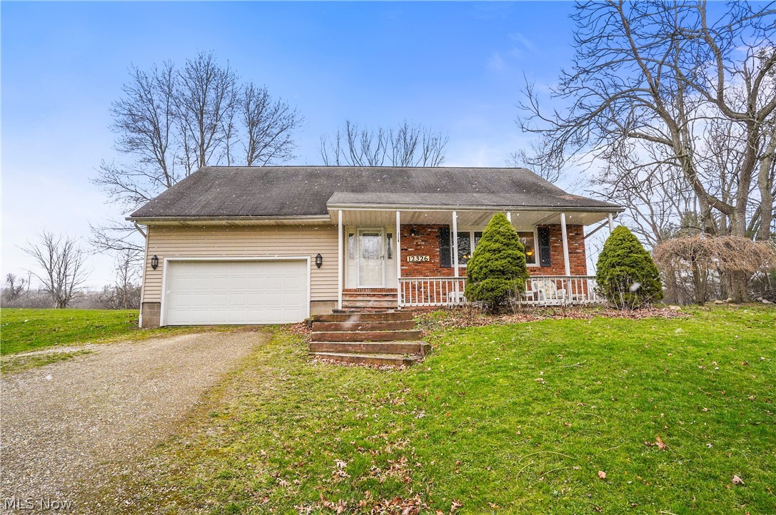 12326 Huntoon Road Painesville, OH 44077 - Photo 1 of 38 View of front of house featuring covered porch, a front yard, and a garage