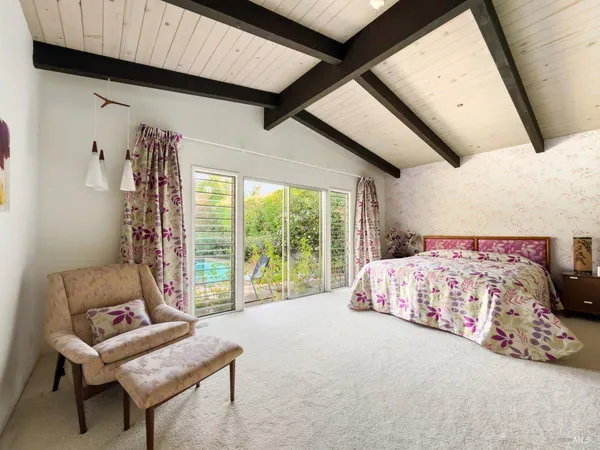 a bedroom with a bed and a large window