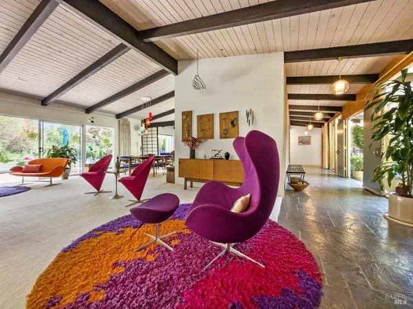 a living room with furniture kitchen view and a large window