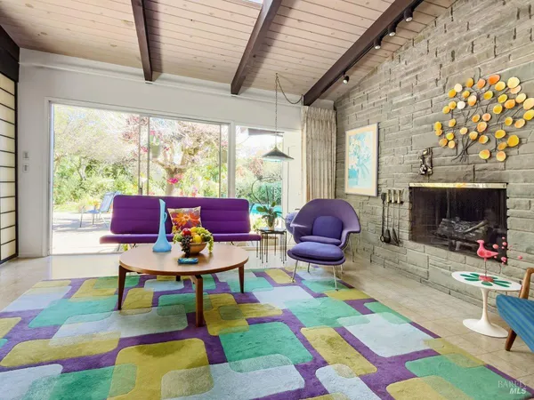 a living room with patio furniture and a fireplace