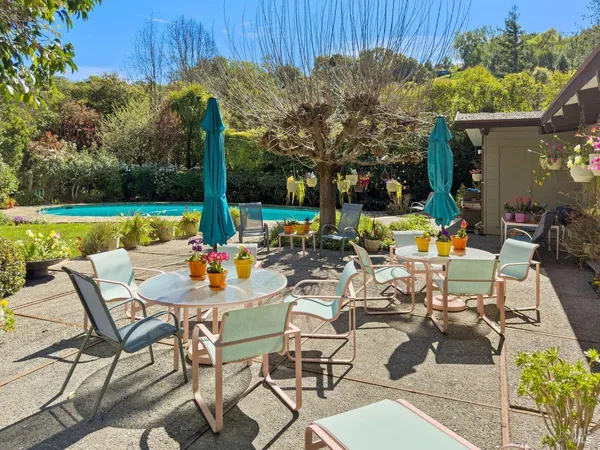 a view of an chairs and table in patio with a yard