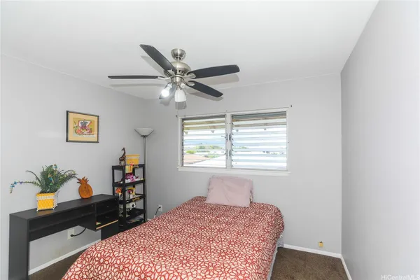 a bedroom with a bed a dresser and a window