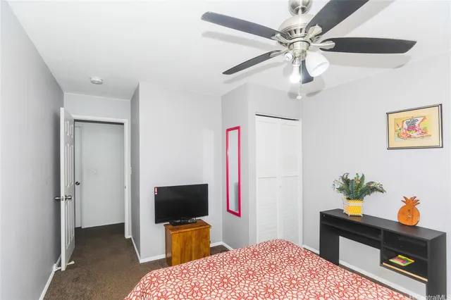 a bedroom with a bed and a flat tv screen on a dresser