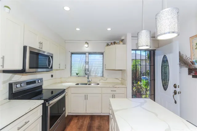 a kitchen with a sink stainless steel appliances a refrigerator and a stove