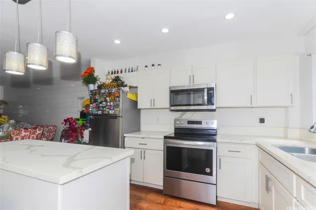a kitchen that has a lot of white cabinets and white appliances