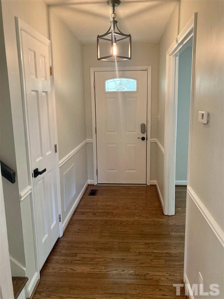6408 Johnsdale Road Raleigh, NC 27615 - Photo 12 of 29 a view of a hallway with wooden floor and staircase
