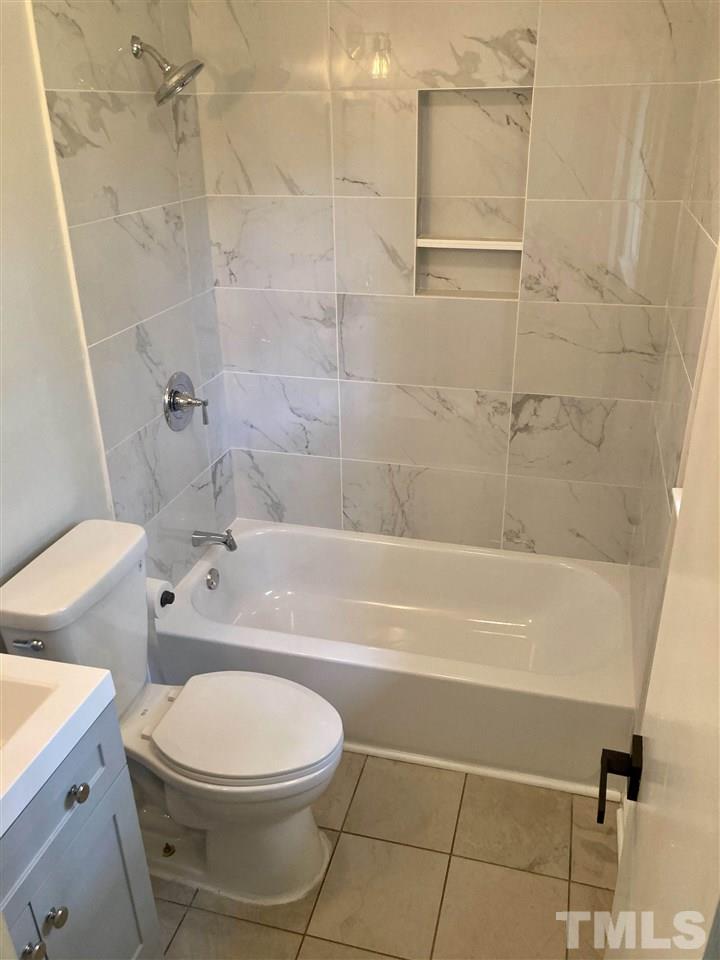 6408 Johnsdale Road Raleigh, NC 27615 - Photo 16 of 29 a bathroom with a toilet a sink and a shower