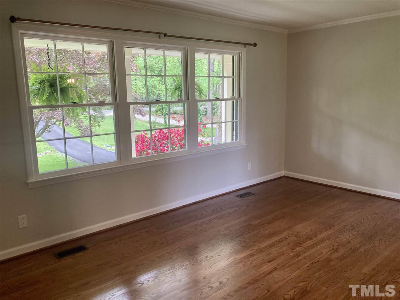 6408 Johnsdale Road Raleigh, NC 27615 - Photo 3 of 29 a view of an empty room with wooden floor and a window