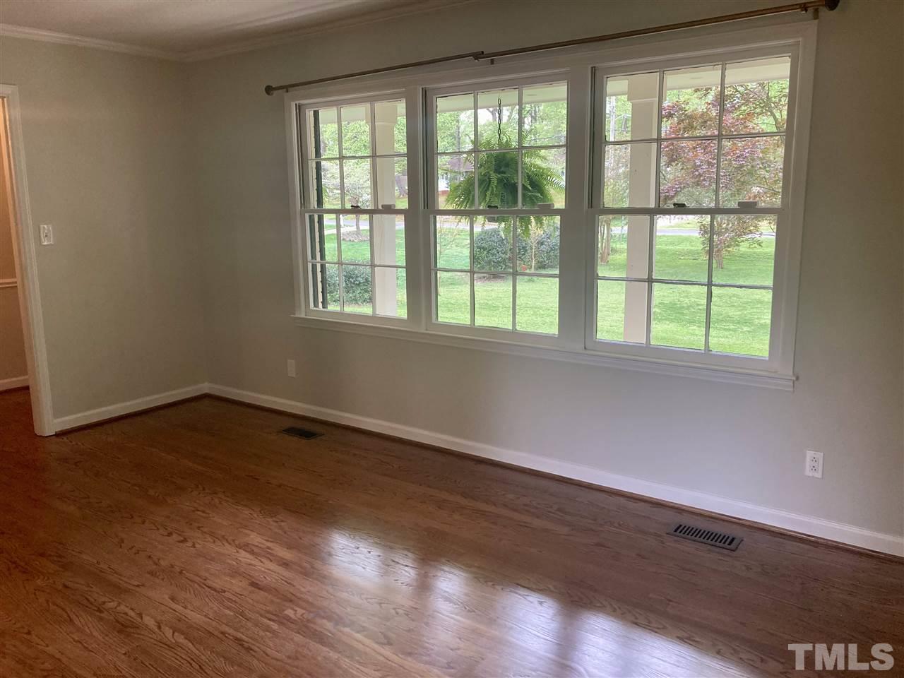 6408 Johnsdale Road Raleigh, NC 27615 - Photo 4 of 29 a view of an empty room with wooden floor and a window