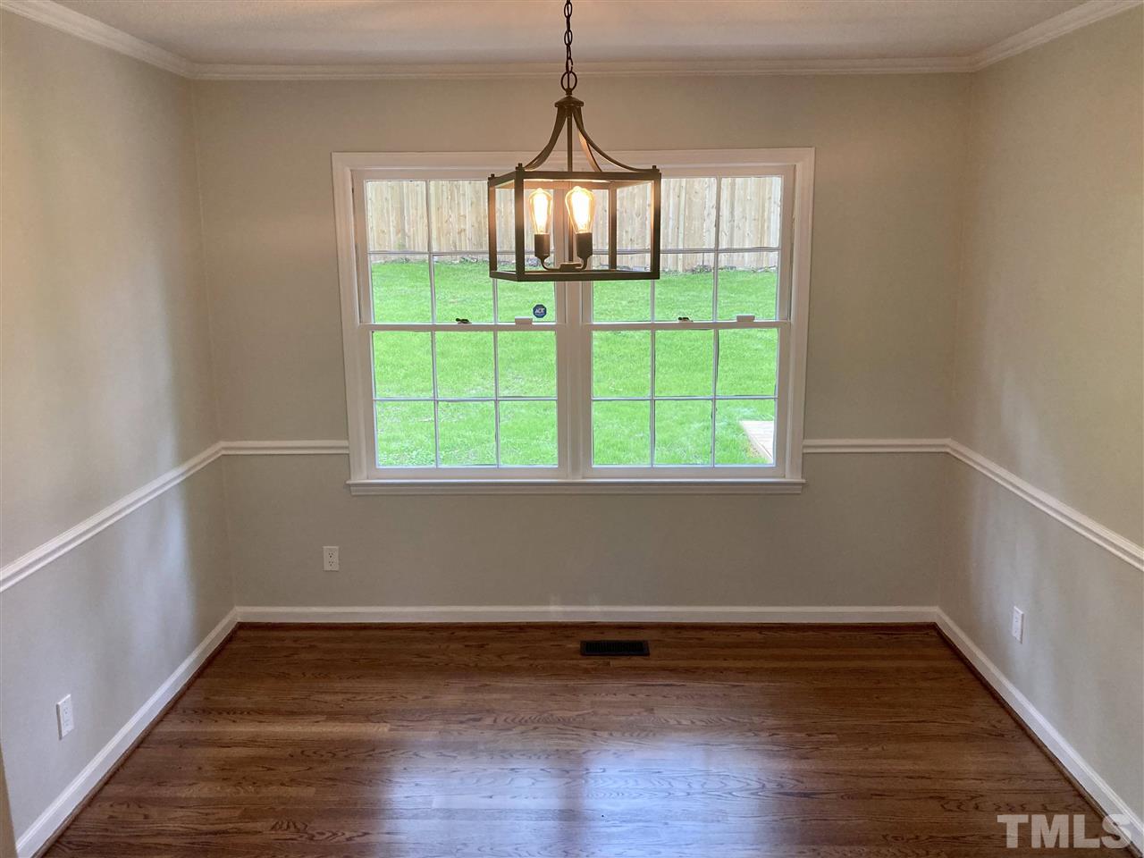 6408 Johnsdale Road Raleigh, NC 27615 - Photo 5 of 29 a view of an empty room with wooden floor and a window