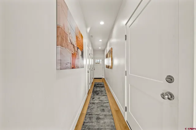 a view of a hallway with wooden floor and staircase