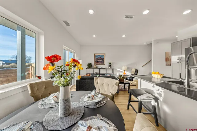 a living room with furniture and a dining table with wooden floor