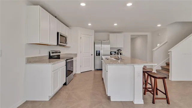a kitchen with white cabinets and stainless steel appliances
