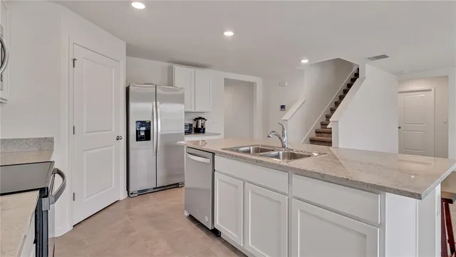 a kitchen with white cabinets and refrigerator