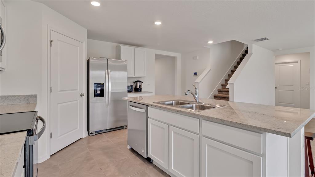 16614 Windmill Forge Pass Wimauma, FL 33598 - Photo 12 of 18 a kitchen with white cabinets and refrigerator