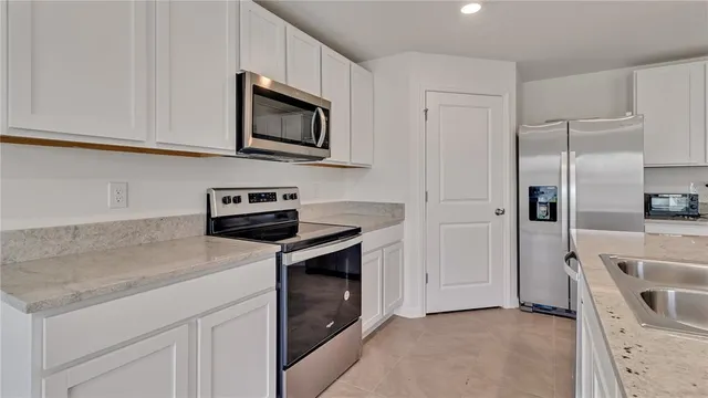 a kitchen with white cabinets and stainless steel appliances
