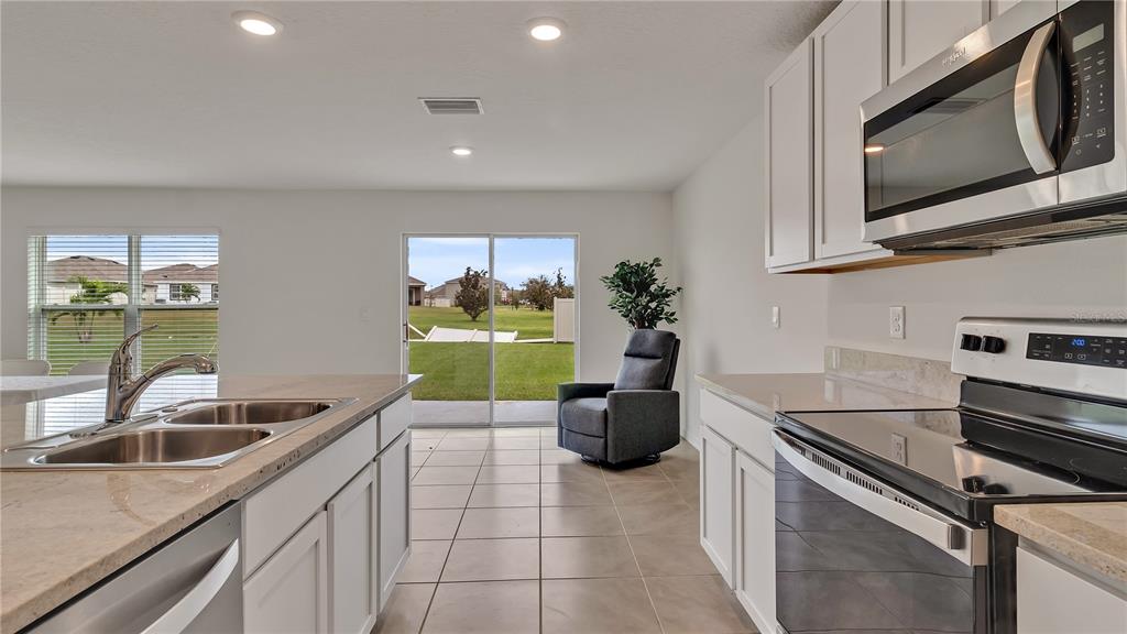 16614 Windmill Forge Pass Wimauma, FL 33598 - Photo 14 of 18 a kitchen with a sink a stove and cabinets