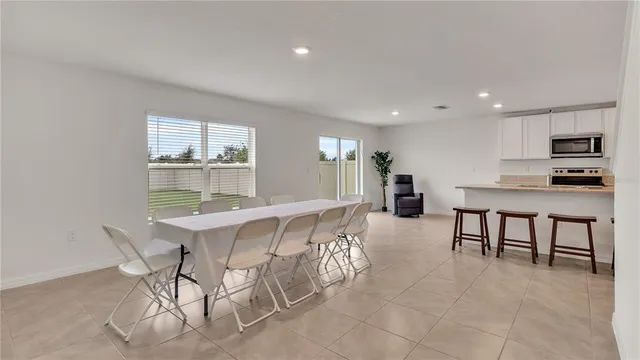 a dining hall with stainless steel appliances a dining table and chairs