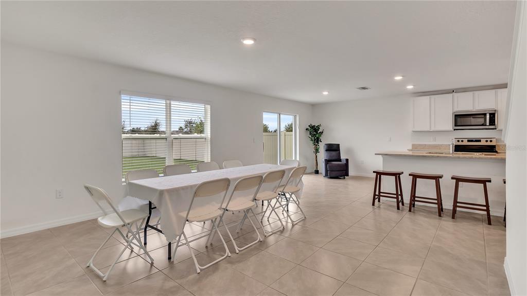 16614 Windmill Forge Pass Wimauma, FL 33598 - Photo 17 of 18 a dining hall with stainless steel appliances a dining table and chairs