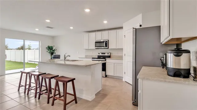 a kitchen with stainless steel appliances granite countertop a stove a sink a refrigerator and a refrigerator