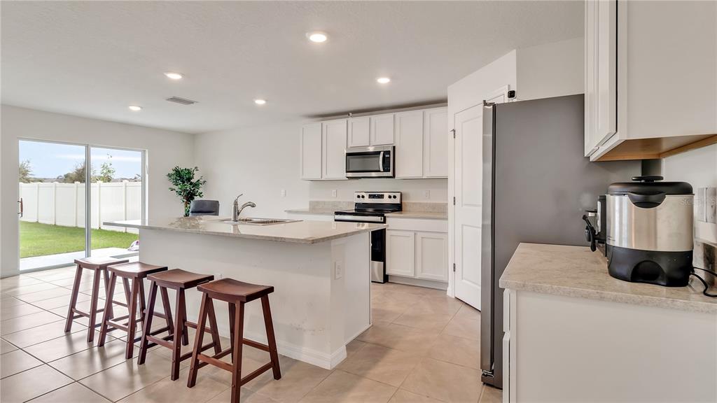 16614 Windmill Forge Pass Wimauma, FL 33598 - Photo 8 of 18 a kitchen with stainless steel appliances granite countertop a stove a sink a refrigerator and a refrigerator
