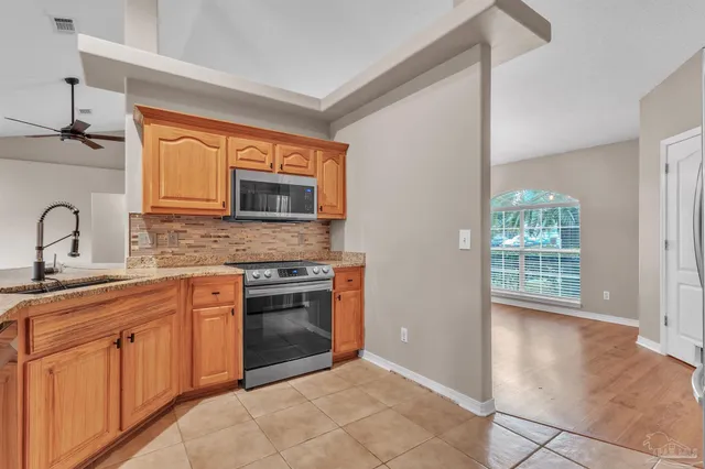a kitchen with stainless steel appliances granite countertop a stove a sink and a microwave